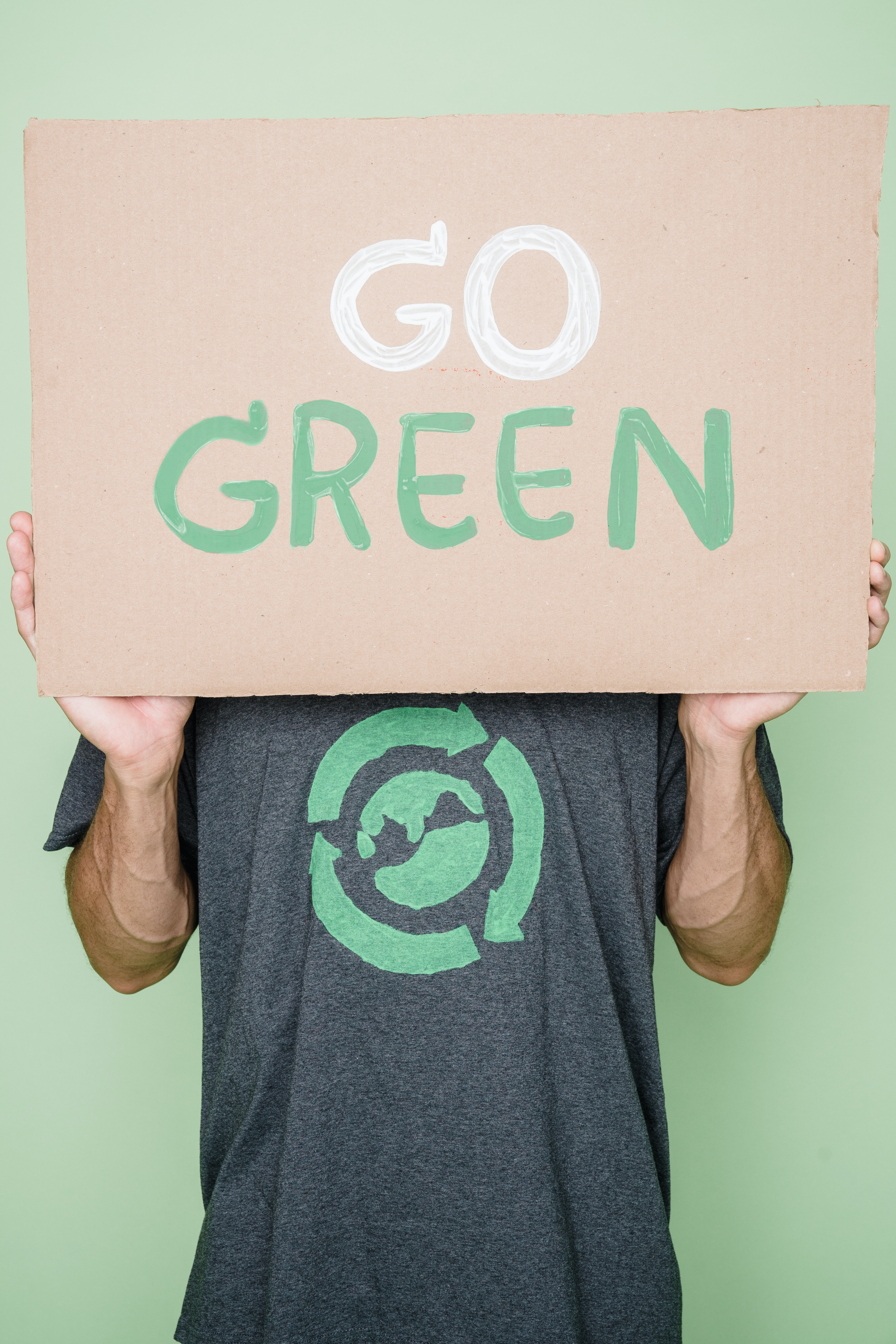 pessoa com placa escrita Go Green